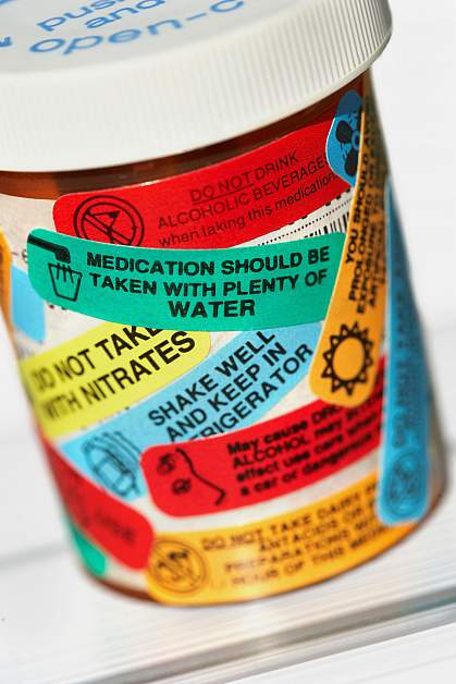 Pill bottle with many warning labels Pill bottle with many warning labels.