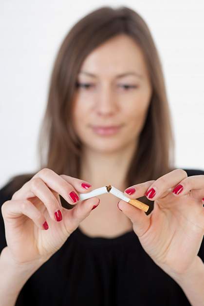 Woman snapping a cigarette in half.