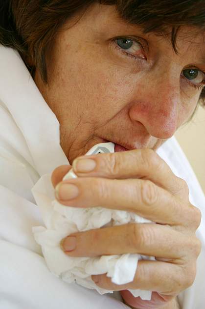 Woman holding a crumpled tissue Woman holding a crumpled tissue.