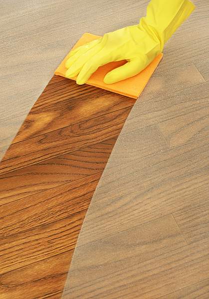 Person dusting a wood table with a cloth Person dusting a wood table with a cloth.