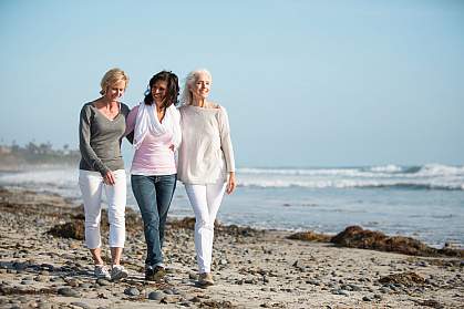 Three mature women walking on a windy beach. Three mature women walking on a windy beach.