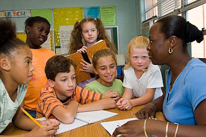 Photo of a teacher giving a lesson to engaged students. Photo of a teacher giving a lesson to engaged students.