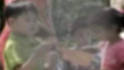 Photo of children playing, obscured in center by large gray area Photo of children playing, obscured in center by large gray area.