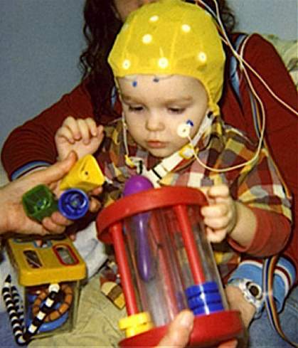 A child wearing a cap to measure brain activity. A child wearing a cap to measure brain activity