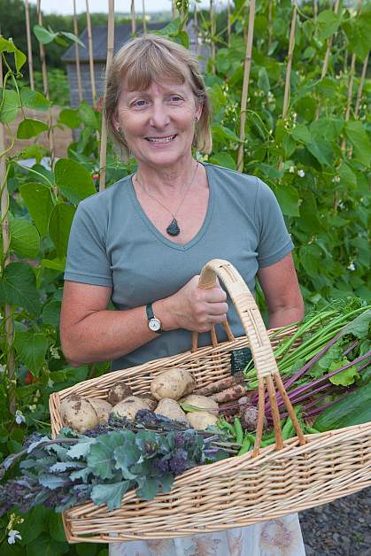 Happy woman with a wicker basket full of fresh vegetables Happy woman with a wicker basket full of fresh vegetables.