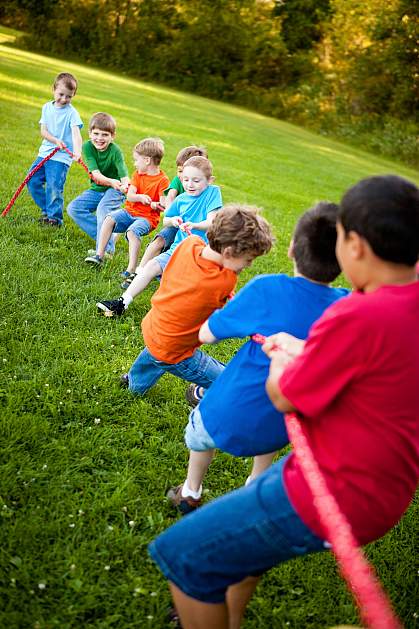 Young boys pulling on a rope in tug of war game.