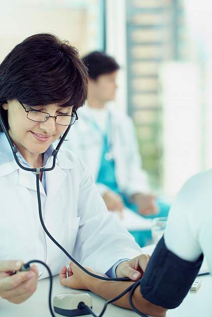 Female doctor checking patient’s blood pressure Female doctor checking patient’s blood pressure.