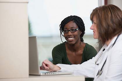 A woman and her doctor at a computer. A woman and her doctor at a computer.