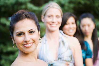 A woman smiling, with other woman in the background A woman smiling, with other woman in the background.