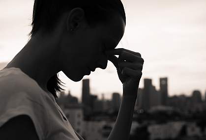 Silhouette of a woman resting her head in her hands Silhouette of a woman resting her head in her hands.