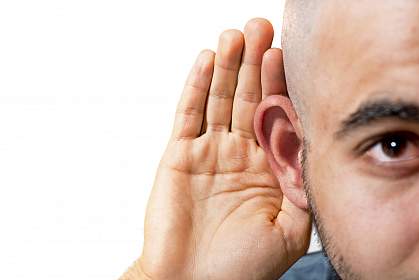 Man cupping his hand to his ear Man cupping his hand to his ear.
