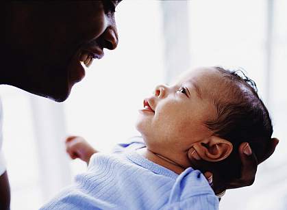 Father and newborn baby Father and newborn smiling at each other.