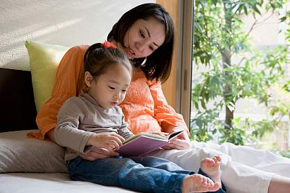 Mother and daughter reading a picture book. Mother and daughter reading a picture book.