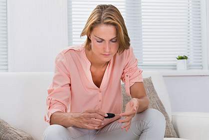 Woman checking blood sugar level Woman checking blood sugar level