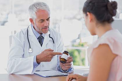 Doctor explaining a bottle of pills to a patient Doctor explaining a bottle of pills to a patient