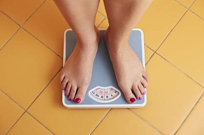 Young woman’s feet on a bathroom scale Young woman’s feet on a bathroom scale