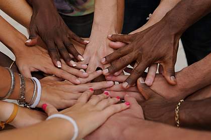 Diverse people stacking their hands together Diverse people stacking their hands together