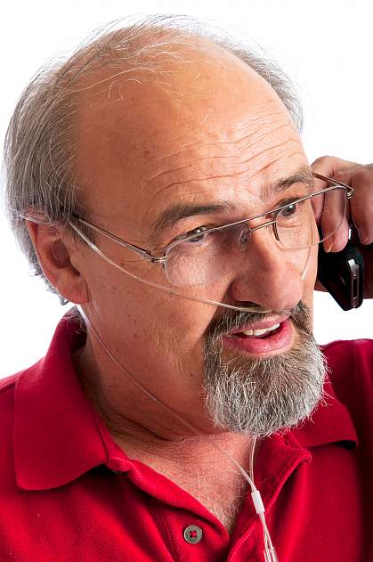Man talking on the phone while receiving oxygen through a thin nasal tube Man talking on the phone while receiving oxygen through a thin nasal tube.