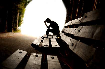 Person sitting alone on a bench in a tunnel. Person sitting alone on a bench in a tunnel.
