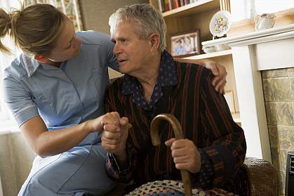 Volunteer visiting senior man with a cane