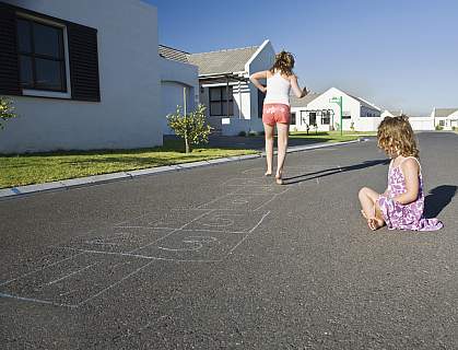 Two girls playing hopscotch on the street Two girls playing hopscotch on the street