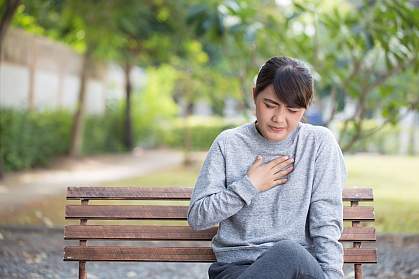 Woman on park bench with heartburn Woman on park bench with heartburn