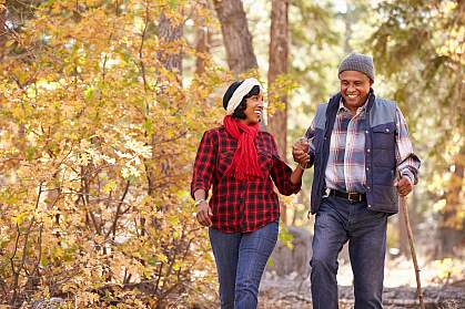 Senior African American couple walking through the woods Senior African American couple walking through the woods