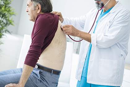 Doctor listening to older man’s lungs Doctor listening to older man’s lungs.
