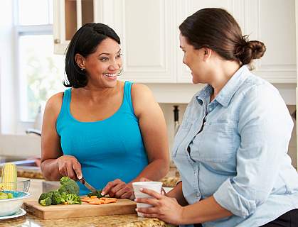 Two overweight women preparing vegetables in the kitchen Two overweight women preparing vegetables in the kitchen