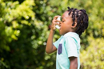 Child using an asthma inhaler Child using an asthma inhaler