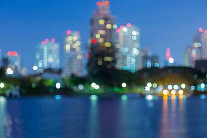 An urban landscape at night that shows lights in office buildings, suggesting people at work.