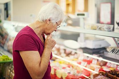 Woman examining cheeses at a market Woman examining cheeses at a market