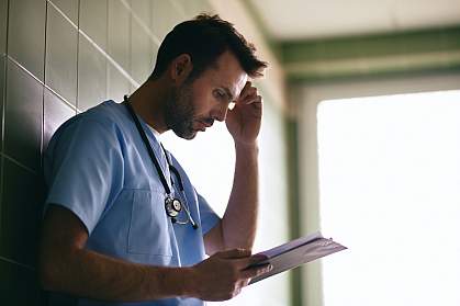 Stressed doctor reading letter Stressed doctor reading letter