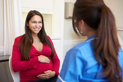 A pregnant woman talking to a health care professional A pregnant woman talking to a health care professional