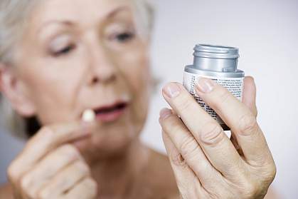 Senior woman holding a bottle of pills Senior woman holding a bottle of pills