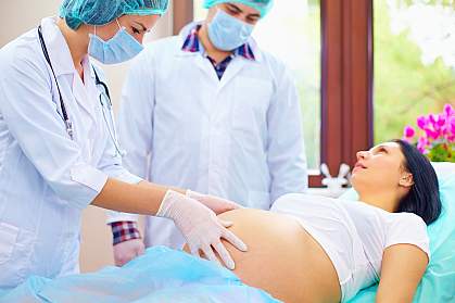 Doctor examines the abdomen of pregnant woman during childbirth Doctor examines the abdomen of pregnant woman during childbirth