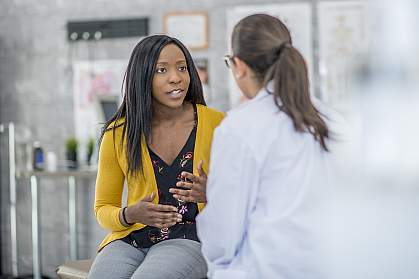 Woman describing symptoms to a doctor Woman describing symptoms to a doctor.