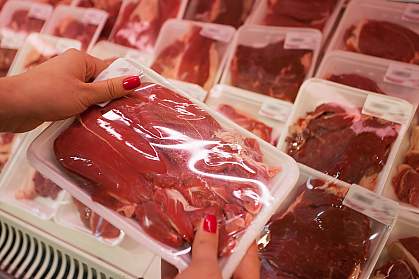 Woman holding packaged meat in the supermarket.