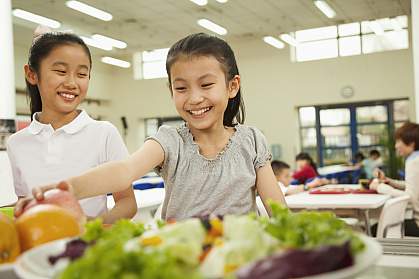 Students reaching for healthy food in school cafeteria Students reaching for healthy food in school cafeteria.