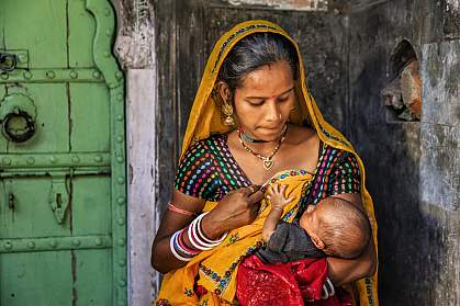 Indian woman feeding her newborn baby Indian woman feeding her newborn baby