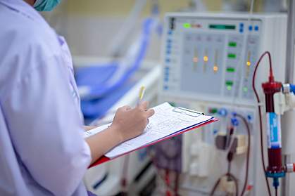 Nurse checking a dialysis machine Nurse checking a dialysis machine