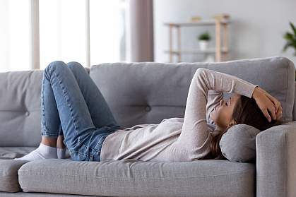 Young woman on couch Tired young woman lying on a couch