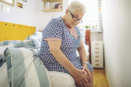 Senior woman holding her knee Senior woman holding her knee