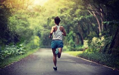 Woman running on a park trail Woman running on a park trail