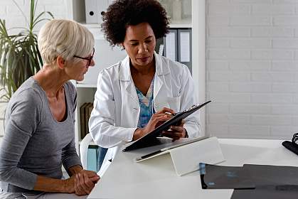Female doctor talking with an elderly patient about test results Female doctor talking with an elderly patient about test results