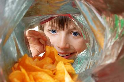 View from inside a potato chip bag of a boy enthusiastically looking in View from inside a potato chip bag of a boy enthusiastically looking in