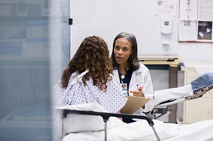 Female patient in a hospital bed talking to a doctor Female patient in a hospital bed talking to a doctor