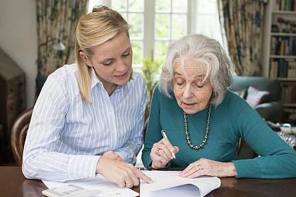 Woman helping senior with paperwork Woman helping senior with paperwork