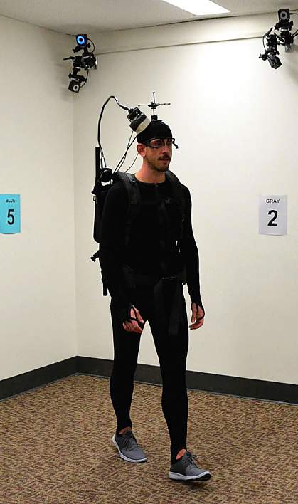 Man walking around room in backpack and headset