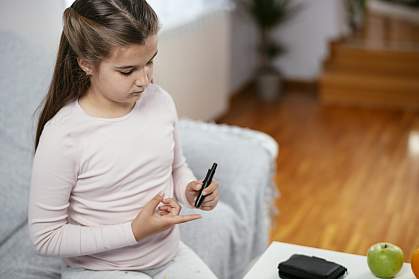 Teenage girl checking her blood sugar level